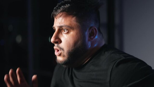 Overweight man running in place as a cardio exercise in a dark gym training hard fast pace