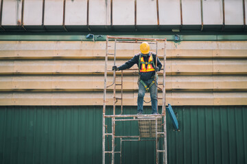 Construction worker wearing safety harnesses on Scaffolding at construction site. working at...
