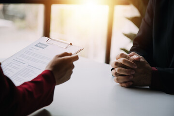 Close up view of job interview in office, focus on resume writing tips, employer reviewing good cv of prepared skilled applicant, recruiter considering application, hr manager making hiring decision