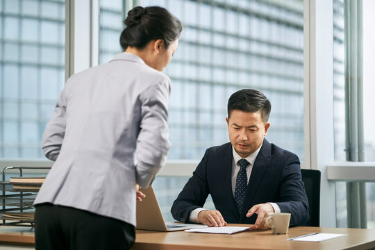 asian business manager reviewing report in office
