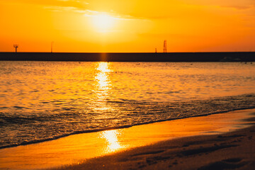 Reflection of sunlight over sea surface at sunset. Orange and gold blue sky. Scenic Gold sea....