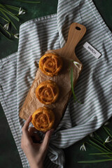 A wooden tray with fresh muffins is on the table. Next to it is the inscription March, April