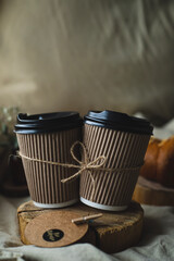 A pair of paper cups filled with coffee. Morning in bed. Romantic morning
