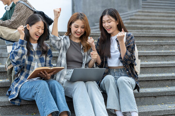 A group of young Asian female students who enjoy searching for scientific information on the field meets together to discuss and record in a notebook together.