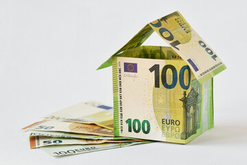 House made of euro banknotes on white background - Concept of building bonus, real estate investment, mortgage and home insurance - 586462887