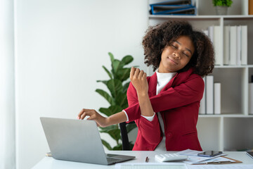 Fototapeta na wymiar Elegant african american businesswoman in formal dress stretching during break relax while working on laptop recording financial business meeting at office desk.