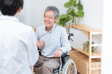 医者と話す高齢の患者（車椅子・介護）