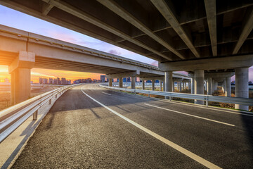 Asphalt road and bridge with city skyline background