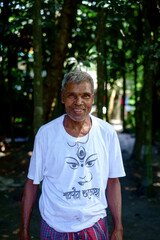 portrait of a south asian senior person wearing white t shirt on which art of goddess durga is drawn, smiling face from a religious festival 