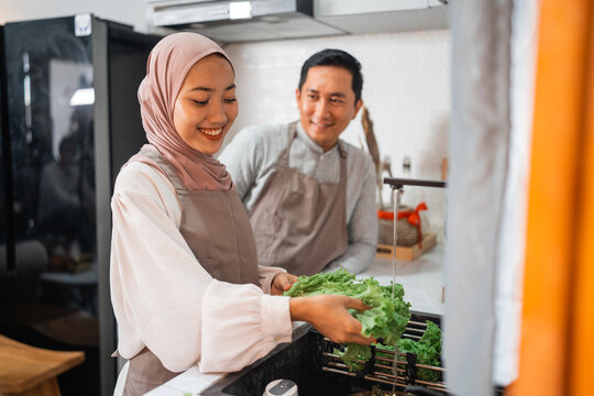 Happy Young Muslim Couple Making Food Together At Home