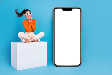 Photo of positive emotion impressed woman in 3d glasses excited to see phone promo placard isolated on blue color background