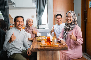 portrait of asian people having dinner together and showing thumb up gesture