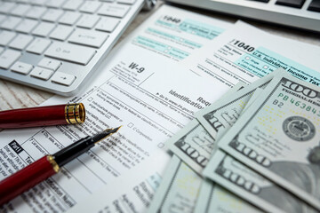 2022 blank tax form with us dollar bills claculator pen on desk