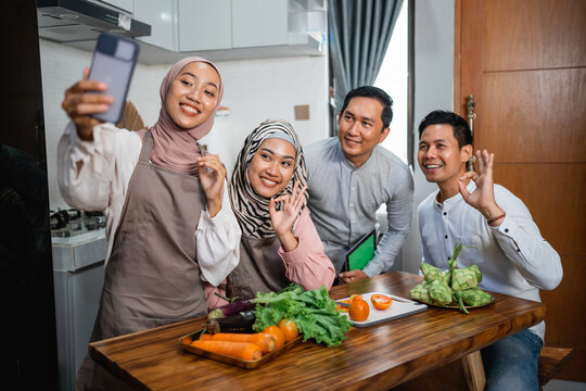 Three Friend With Hijab Looking At The Phone Searching For New Recipe For Dinner