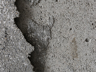 Texture of an old cracked concrete wall. Grungy gray concrete surface with shadow. Perfect for background and design. Close-up. Copy space.