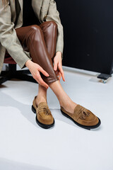 Casual women's fashion. Classic shoes for women. Slender female legs in trousers and brown stylish...