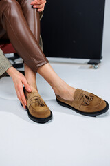 Casual women's fashion. Classic shoes for women. Slender female legs in trousers and brown stylish...
