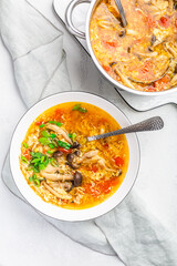 Tomato egg drop soup  with mushrooms and spring onions in a white bowl