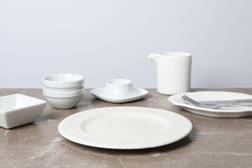 Minimal table setting with blank dish on textured gray table