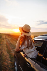 Relaxed happy woman on summer road trip travel vacation leaning out car window. Lifestyle, travel,...