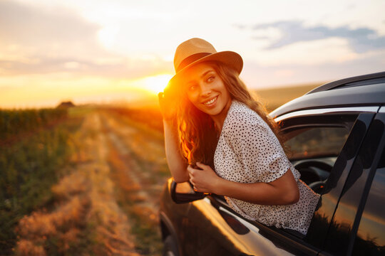 Relaxed happy woman on summer road trip travel vacation leaning out car window. Lifestyle, travel, tourism, nature, active life.