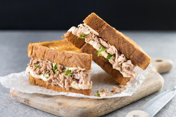 Naklejka na ściany i meble Tuna sandwich with mayo and vegetables on gray stone background.