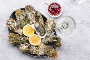 Fresh oysters with sauce and lemons