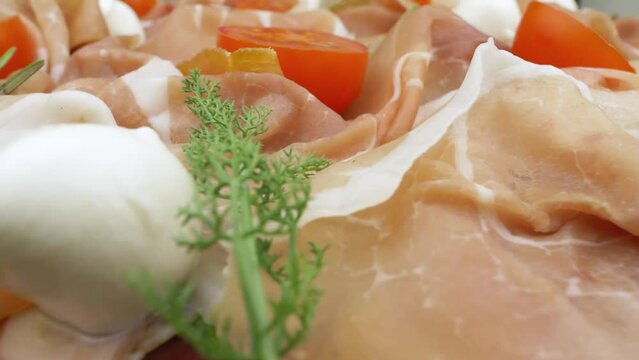 Raw ham. Slices of dried ham with mozzarella and tomatoes. Low-angle view in close up
