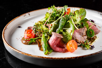 Roast beef salad with vegetables on plate