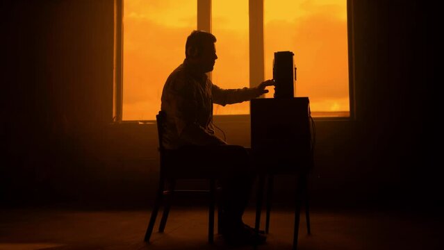 Special agent listens on the reel tape recorder. Officer wiretapping in headphones. KGB spying of conversations. Cold war concept. Sepia, retro colours grading.
