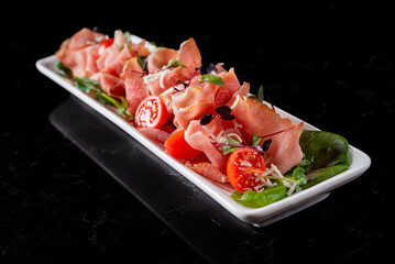 sliced spanish jamon cut, parma ham, serrano or iberico, prosciutto on plate