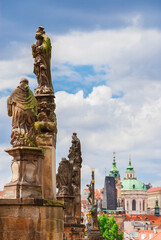 Fototapeta na wymiar Charles Bridge beautiful 18th century baroque statues with Mala Strana Bridge Tower and St Nicholas Church