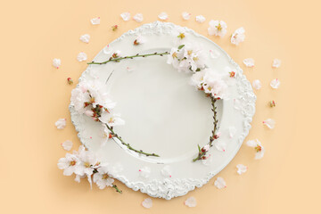 Top view of vintage white empty plate over spring cherry tree flowers. Flat lay