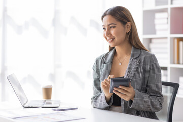Young asian business woman manager accounting analyst checking bills, analyzing sales statistics...