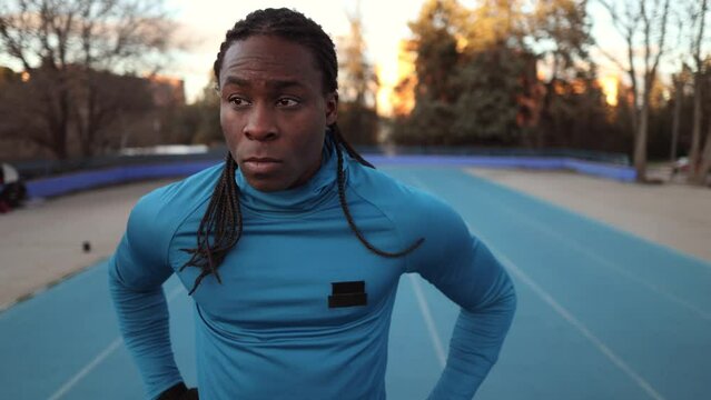 african man sportsman on running track standing looking around