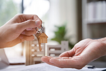 home loan officer gives the house keys to the client after signing a real estate contract.