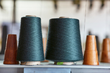 Two bobbins with industrial threads on cones