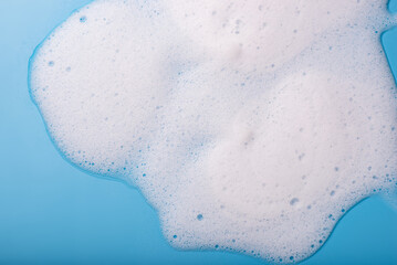 Soap foam on a blue background. The concept of hygiene, cleanliness.