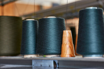 Three bobbins with industrial threads on cones