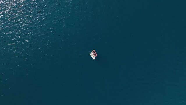 Aerial drone tracking video of red boat cruising in high speed in Mediterranean sea