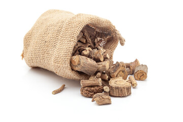 Close-up of Dry Vridha Daru (Argyreia speciosa) barks, spilled out from a laying jute bag over white background.