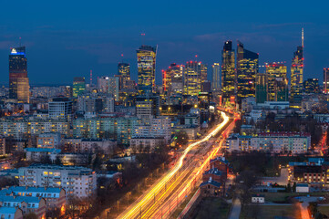Widok, panorama na dzielnicę Wola w Warszawie po zachodzie słońca. Zdjęcie z drona na warszawski Manhattan pełen nowo wybudowanych budynków biurowych - obrazy, fototapety, plakaty