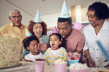 Birthday party, food and surprise with family in kitchen for celebration, bonding and affectionate. Happy, excited and grandparents with parents and child at home for generations, fun or event