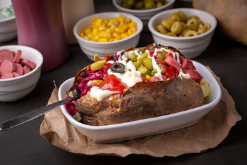 Kumpir, Turkish baked potato with cheese, corn, sausage, ketchup, mayonnaise and olives. This...
