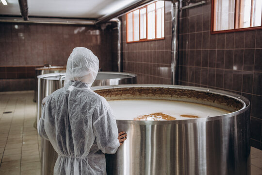 Handsome bearded brewer controlling beer fermentation process at his craft beer factory