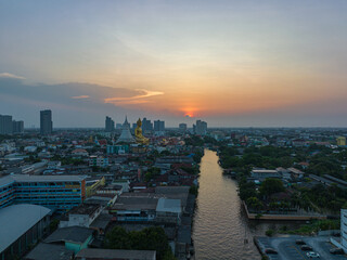 .aerial view golden big Buddha Wat Paknam Phasi Charoen in sunset. .beautiful sunset reflection on a canal in front big buddha. .scenery sky in twilight background.the one famous landmarks