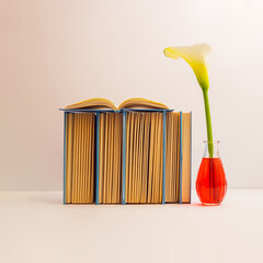 Aesthetic composition of books with white Calla Lily flowers on a pastel beige background. Spring...