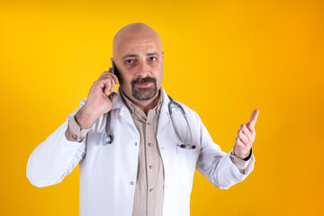 Angry doctor, middle aged caucasian angry doctor on the phone. Portrait of middle aged physician with raised hand holding smartphone looking camera annoyed concept idea. Wearing stethoscope. 