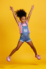 Happy, jump and child hands raised jumping in happiness, joy and smile while isolated in a studio...