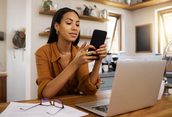 Remote work, phone and texting by business woman in kitchen with laptop, documents and form....